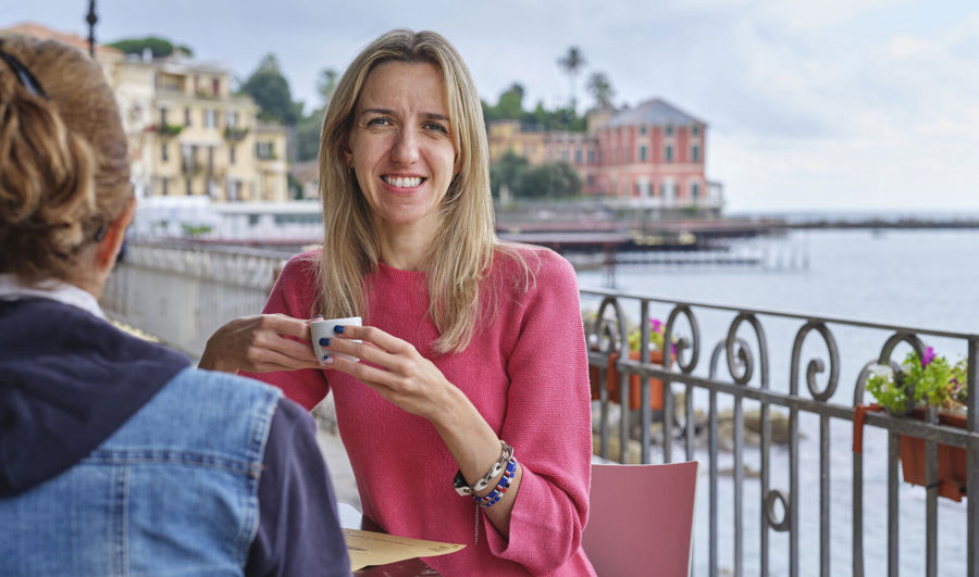  Photo of Elise sitting at a coffee shop. She uses Luja female to manage her bladder symptoms associated with her MS. 