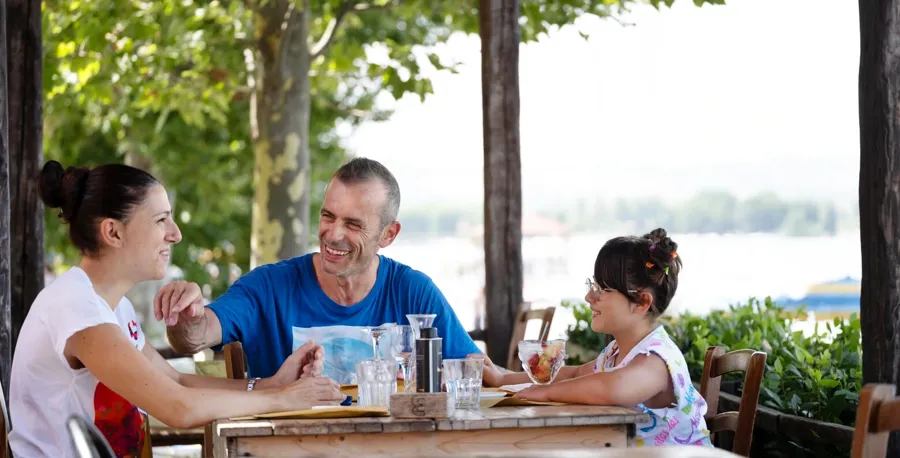 Andrea sits at a restaurant table together with his family. If you have questions or concerns about your bladder and bowel when living with MS, reach out to Coloplast Care for support.  